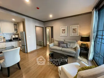 Modern living room with open kitchen, stylish decor, and cozy seating area in a contemporary apartment.