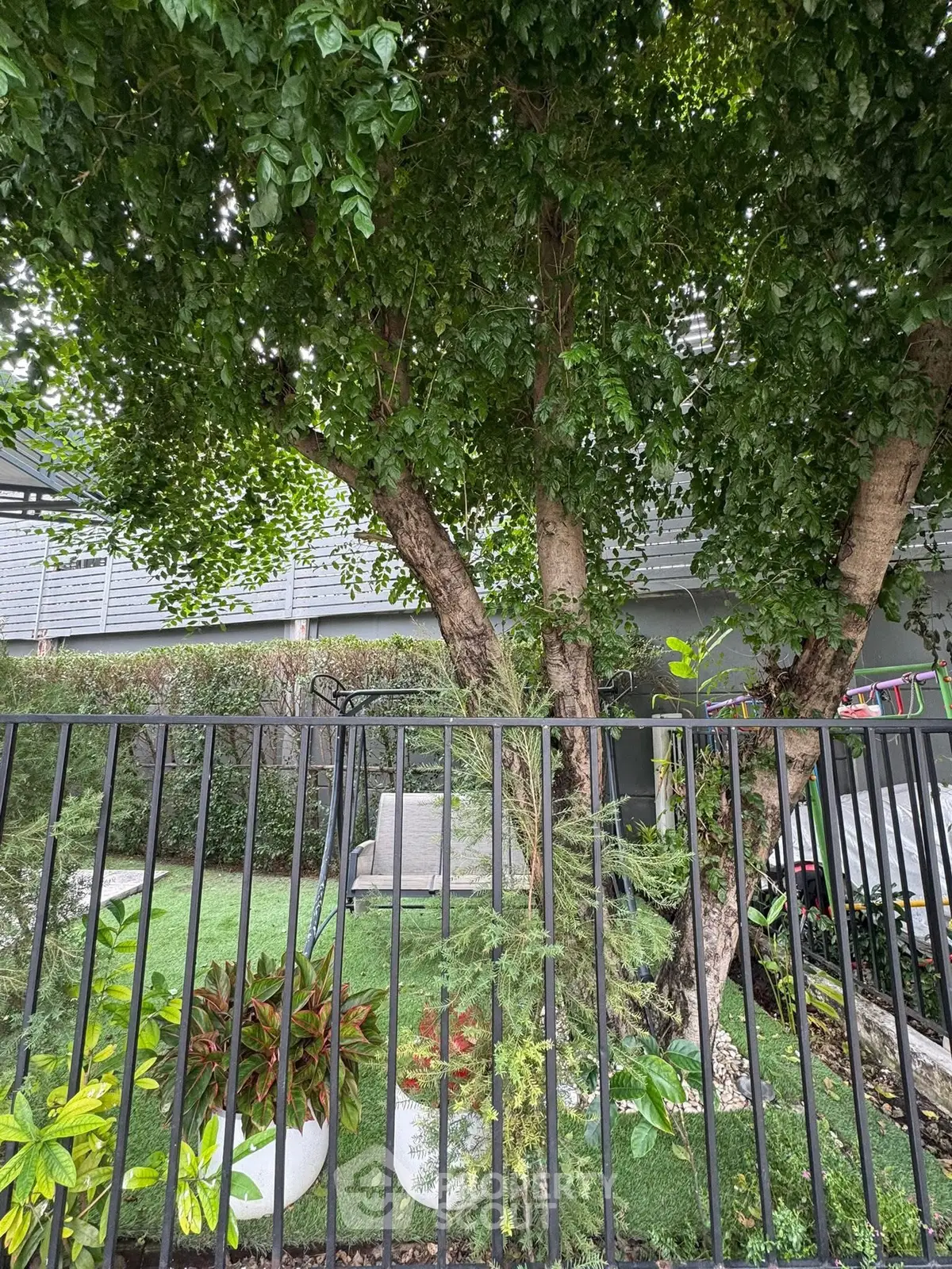 Charming garden with lush greenery and cozy seating area, perfect for relaxation.