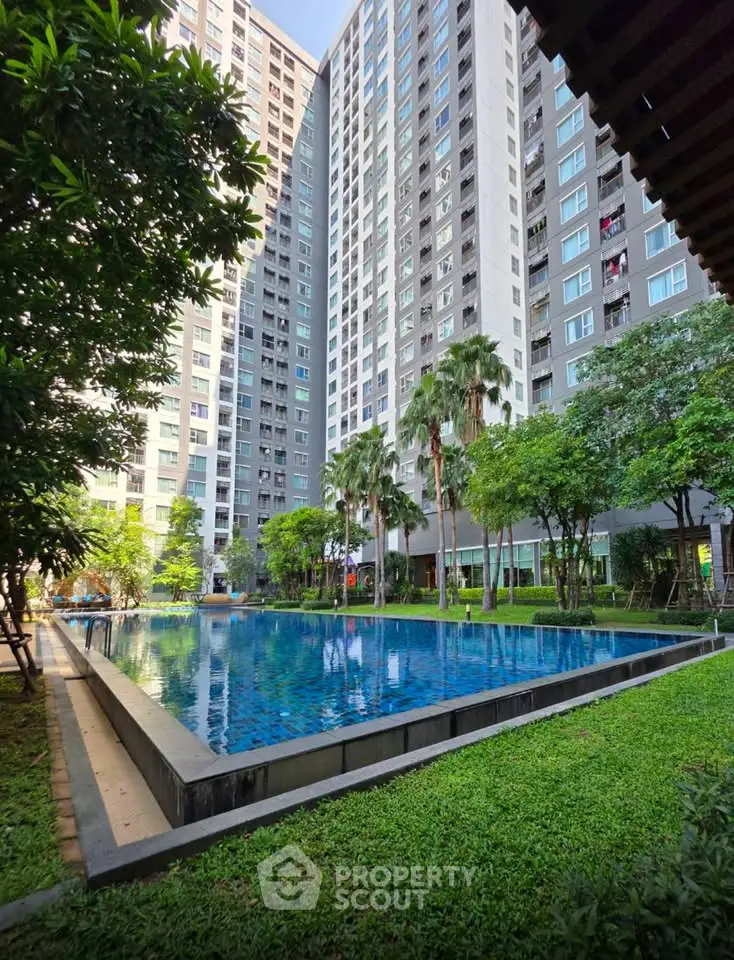 Stunning high-rise apartment complex with lush greenery and inviting swimming pool.