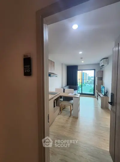 Modern living room with open layout and city view from balcony.