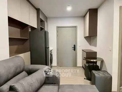 Modern living room with sleek furniture and integrated kitchen appliances.