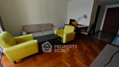 Spacious living room with vibrant yellow chairs and cozy sofa, perfect for relaxation and entertaining.