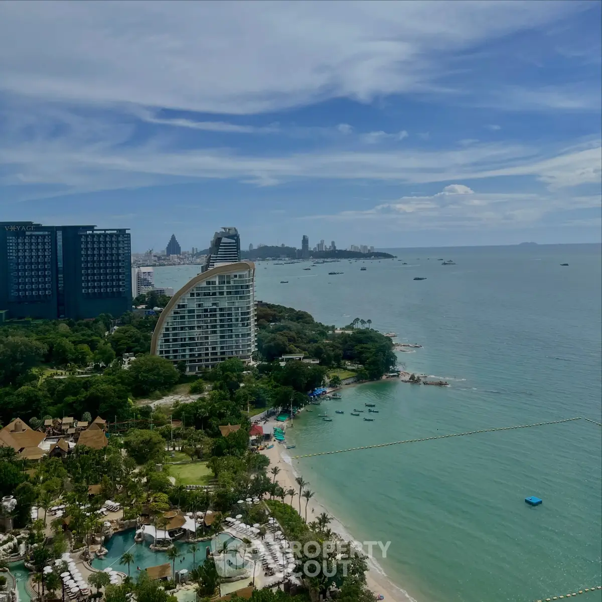 Stunning coastal view from a high-rise building overlooking lush greenery and the ocean, perfect for luxury living.