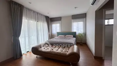 Spacious bedroom with elegant decor and large windows for natural light