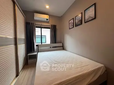 Cozy bedroom with modern decor and ample natural light, featuring a comfortable bed and stylish artwork.