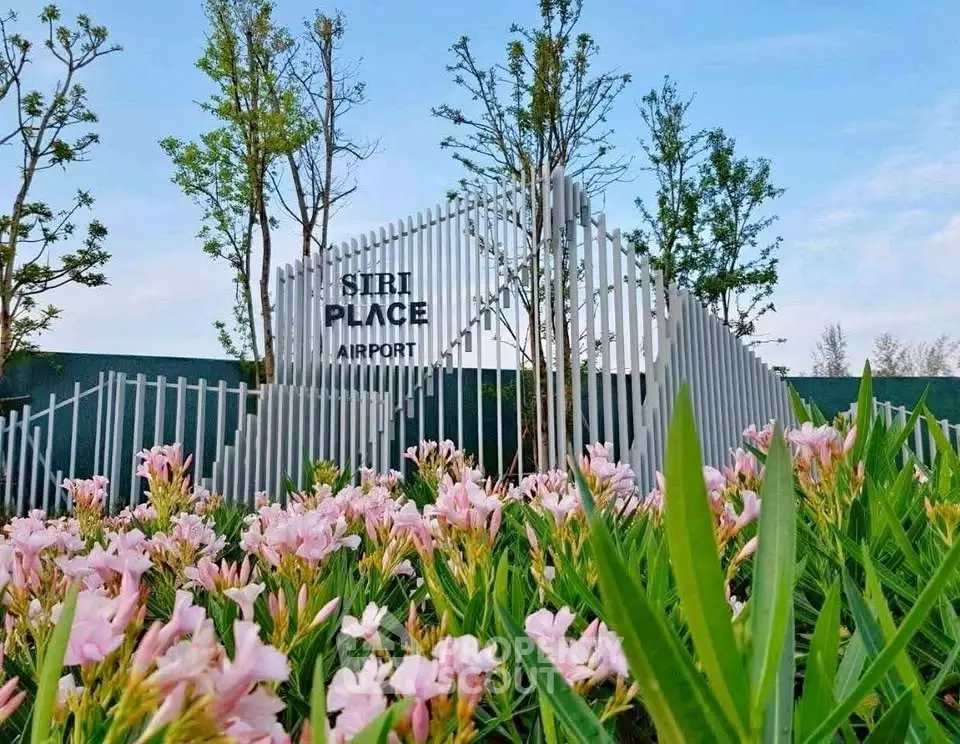 Modern architectural entrance with lush landscaping and vibrant flowers at Siri Place Airport.