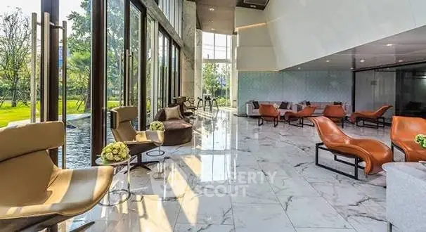 Luxurious lobby with modern seating and floor-to-ceiling windows overlooking a garden.