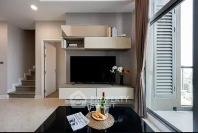 Modern living room with sleek TV unit and balcony view