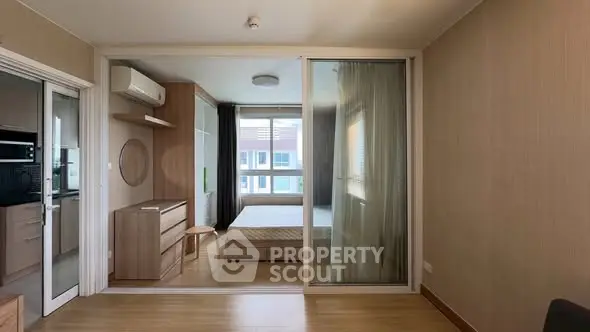 Modern studio apartment with sliding glass partition and natural light