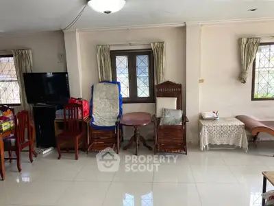 Spacious living room with tiled flooring and wooden furniture, ideal for family gatherings.