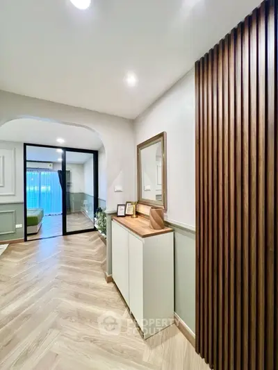 Stylish modern hallway with wooden accents and elegant decor leading to a cozy living area.