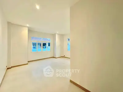 Spacious empty room with large windows and bright natural light