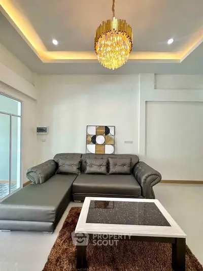 Luxurious living room with elegant chandelier and modern sectional sofa
