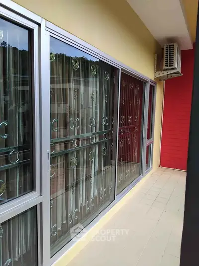 Modern balcony with sliding glass doors and air conditioning unit, perfect for relaxation.