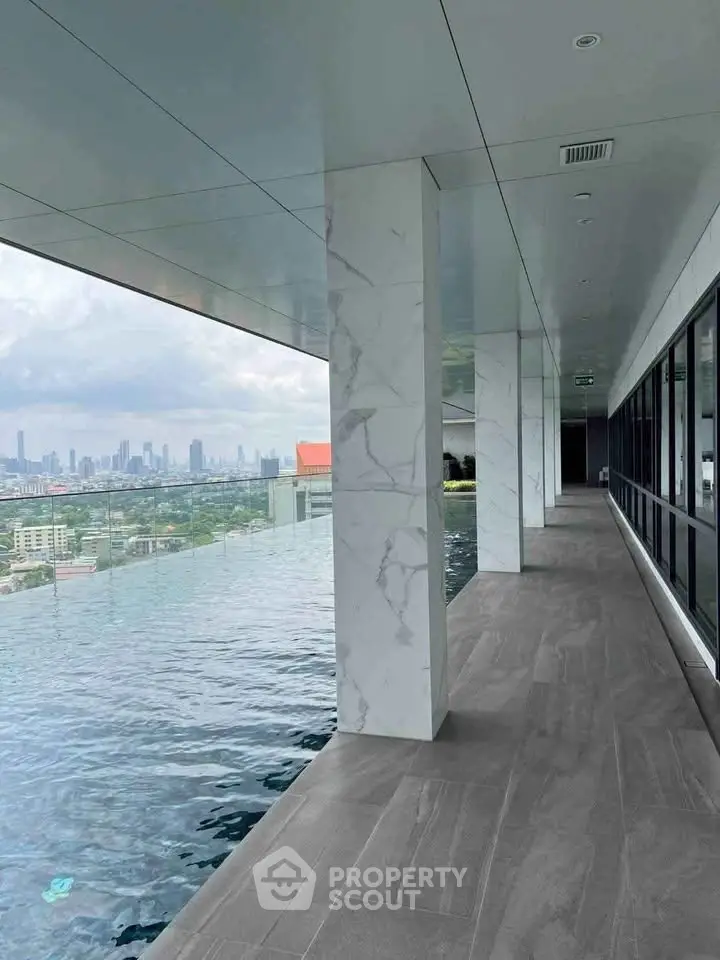 Luxurious rooftop infinity pool with stunning city skyline view, perfect for relaxation and leisure.