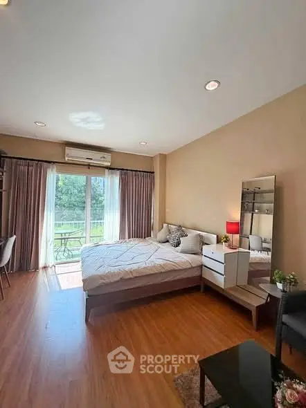 Spacious bedroom with large window and balcony access in modern apartment