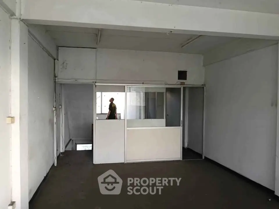 Spacious empty room with partition, ideal for office or studio setup.