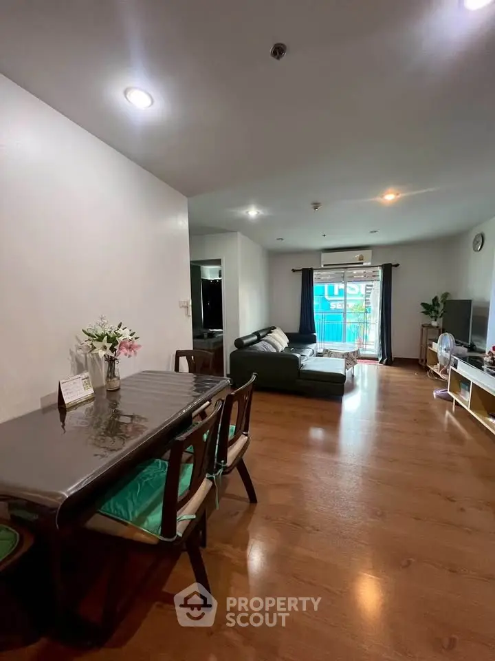 Spacious living room with wooden flooring and modern furniture in a cozy apartment.