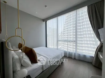 Luxurious bedroom with floor-to-ceiling windows offering stunning city views.