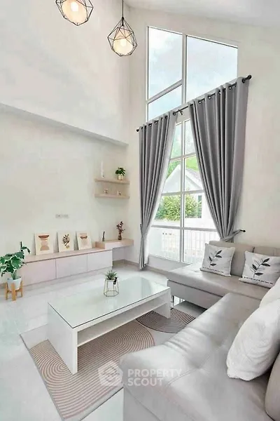 Bright and modern living room with high ceilings and large windows.