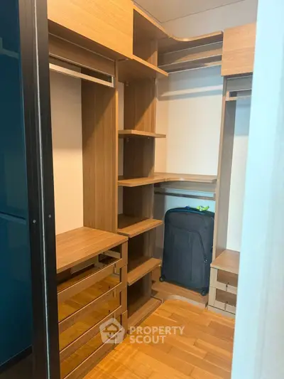 Spacious walk-in closet with wooden shelves and drawers