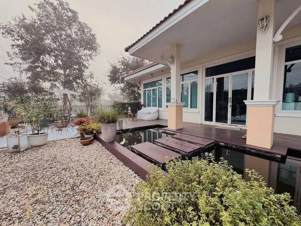 Charming house with serene garden and pond, featuring modern architecture and inviting outdoor space.