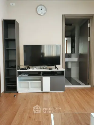 Modern living room with sleek TV stand and open bathroom view, showcasing contemporary design and functionality.