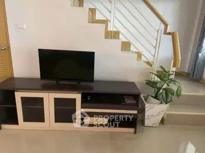 Modern living room with sleek TV stand and stylish staircase