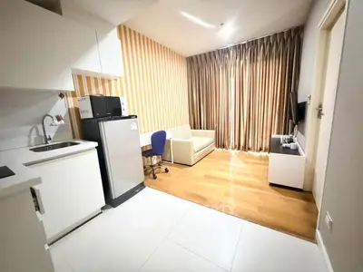 Modern studio apartment with kitchenette and cozy living area, featuring stylish decor and natural light.