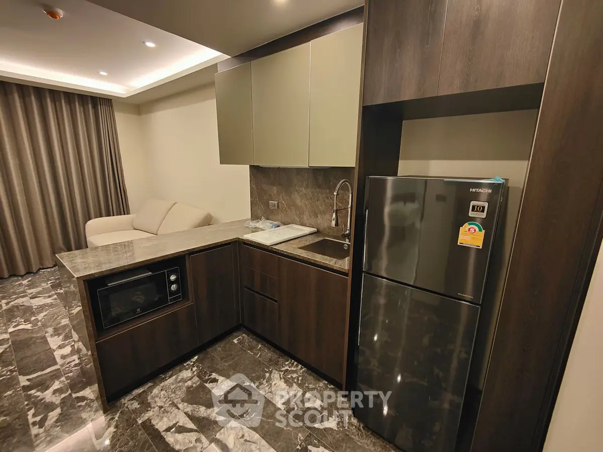 Modern kitchen with sleek cabinetry and marble flooring in a stylish apartment.