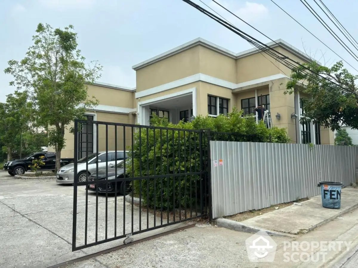 Modern residential building with gated entrance and lush greenery