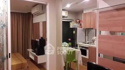 Modern apartment interior with cozy living area and compact kitchen featuring wooden cabinetry and stylish decor.