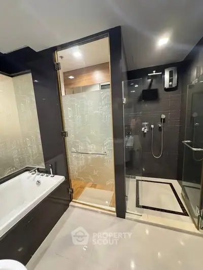 Luxurious modern bathroom with glass shower and bathtub in elegant apartment.