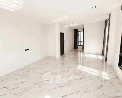 Spacious modern living room with marble flooring and ample natural light