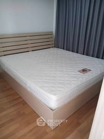 Spacious bedroom with wooden flooring and a comfortable bed, ideal for restful nights.