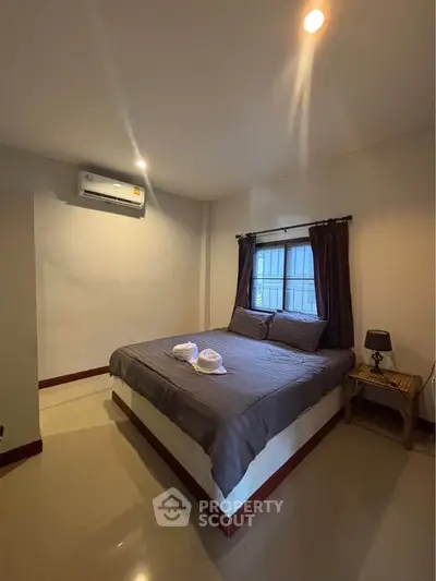 Cozy bedroom with modern decor and air conditioning, perfect for relaxation and comfort.