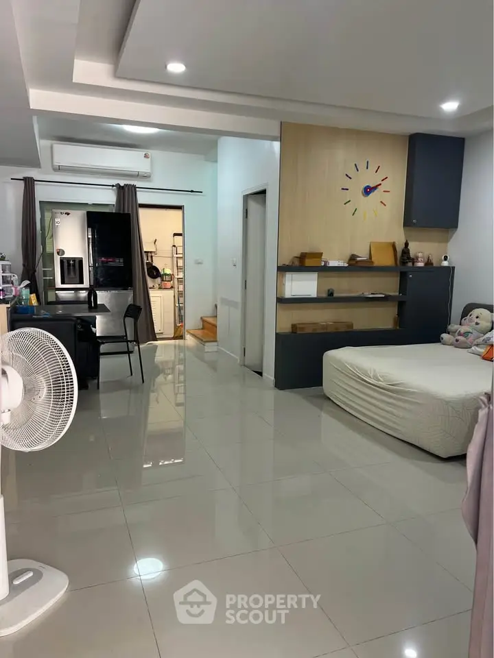Modern open-plan living space with sleek kitchen and cozy bedroom area, perfect for urban living.