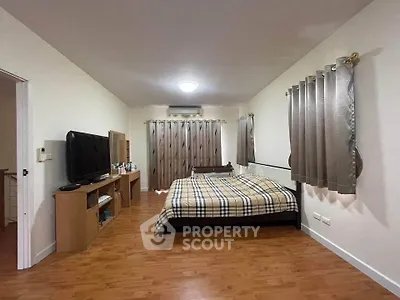 Spacious bedroom with modern decor and wooden flooring