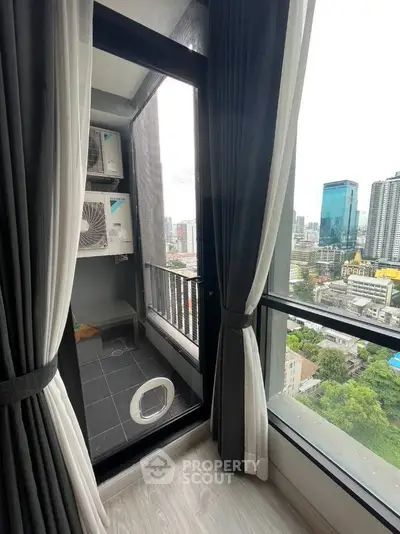 High-rise apartment balcony with city view and modern glass windows.