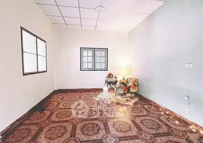 Spacious room with patterned tile flooring and cozy seating area.
