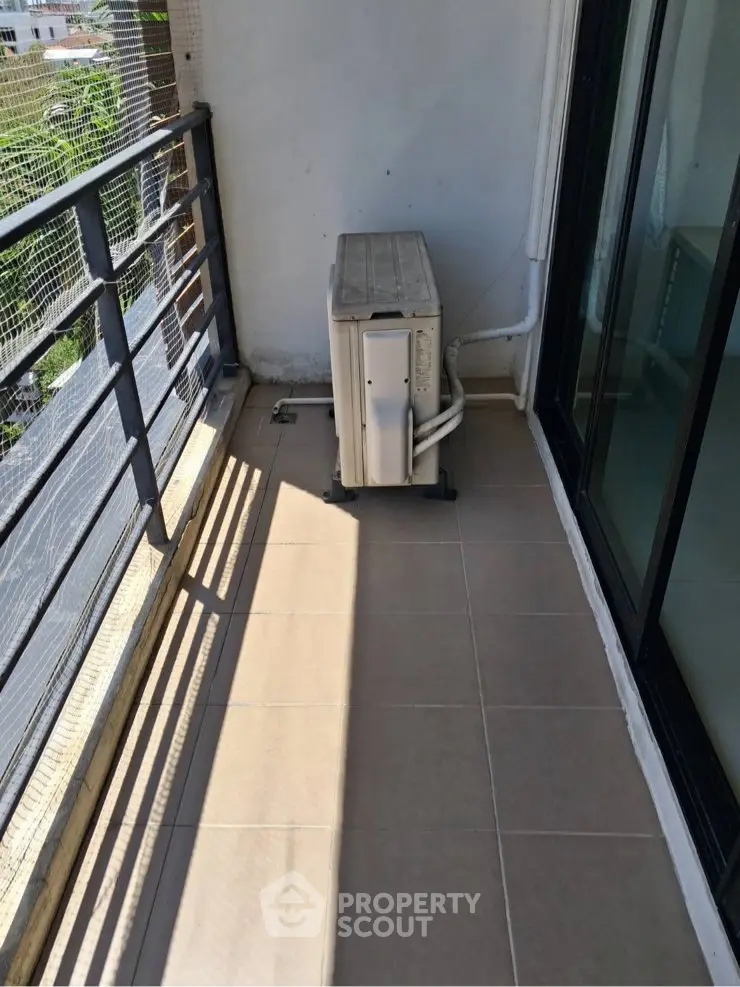 Spacious balcony with air conditioning unit and city view, perfect for relaxation.