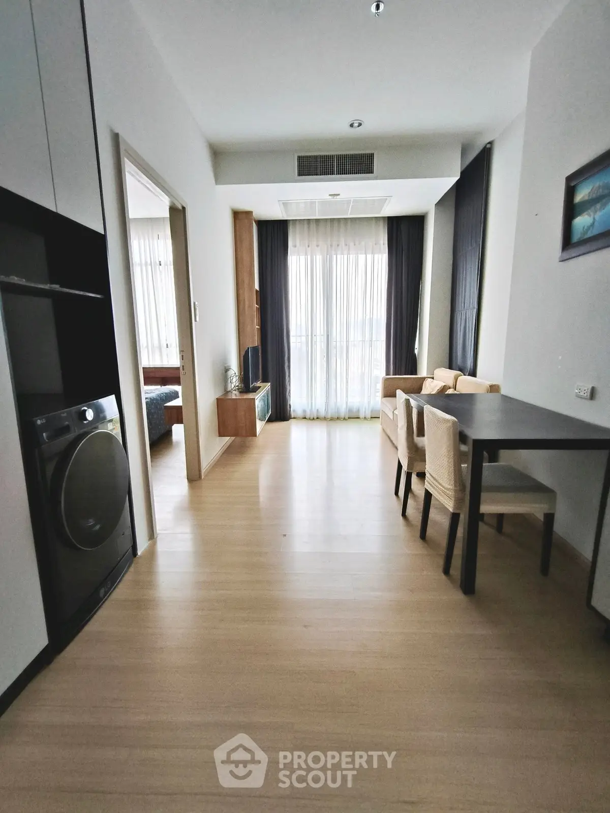 Modern apartment interior with open layout, featuring dining area and cozy living space.
