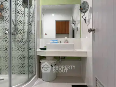 Modern bathroom with glass shower and stylish sink in contemporary home.