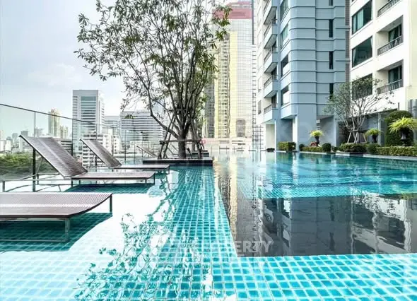 Luxurious rooftop pool with city skyline view in modern high-rise building.