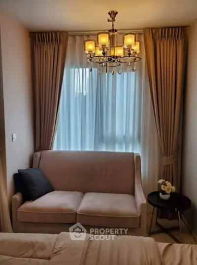 Cozy living room with elegant chandelier and plush sofa near window