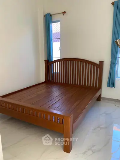 Spacious bedroom with elegant wooden bed and natural light