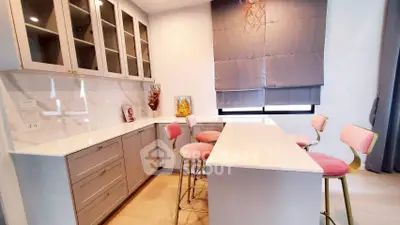 Modern kitchen with sleek cabinets and stylish bar stools in a cozy setting.