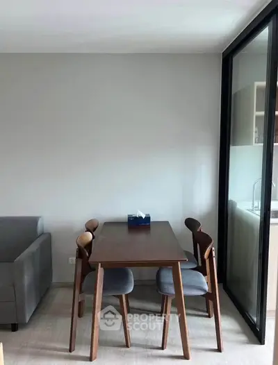 Modern dining area with wooden table and chairs in a cozy apartment setting.