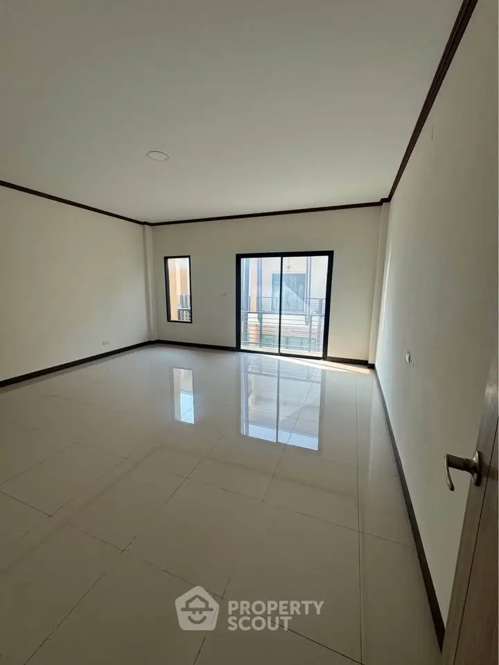 Spacious empty room with large windows and glossy tiled floor, perfect for customization.