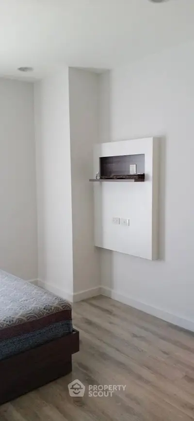 Modern bedroom with sleek design and minimalist decor, featuring a stylish bed and wooden flooring.